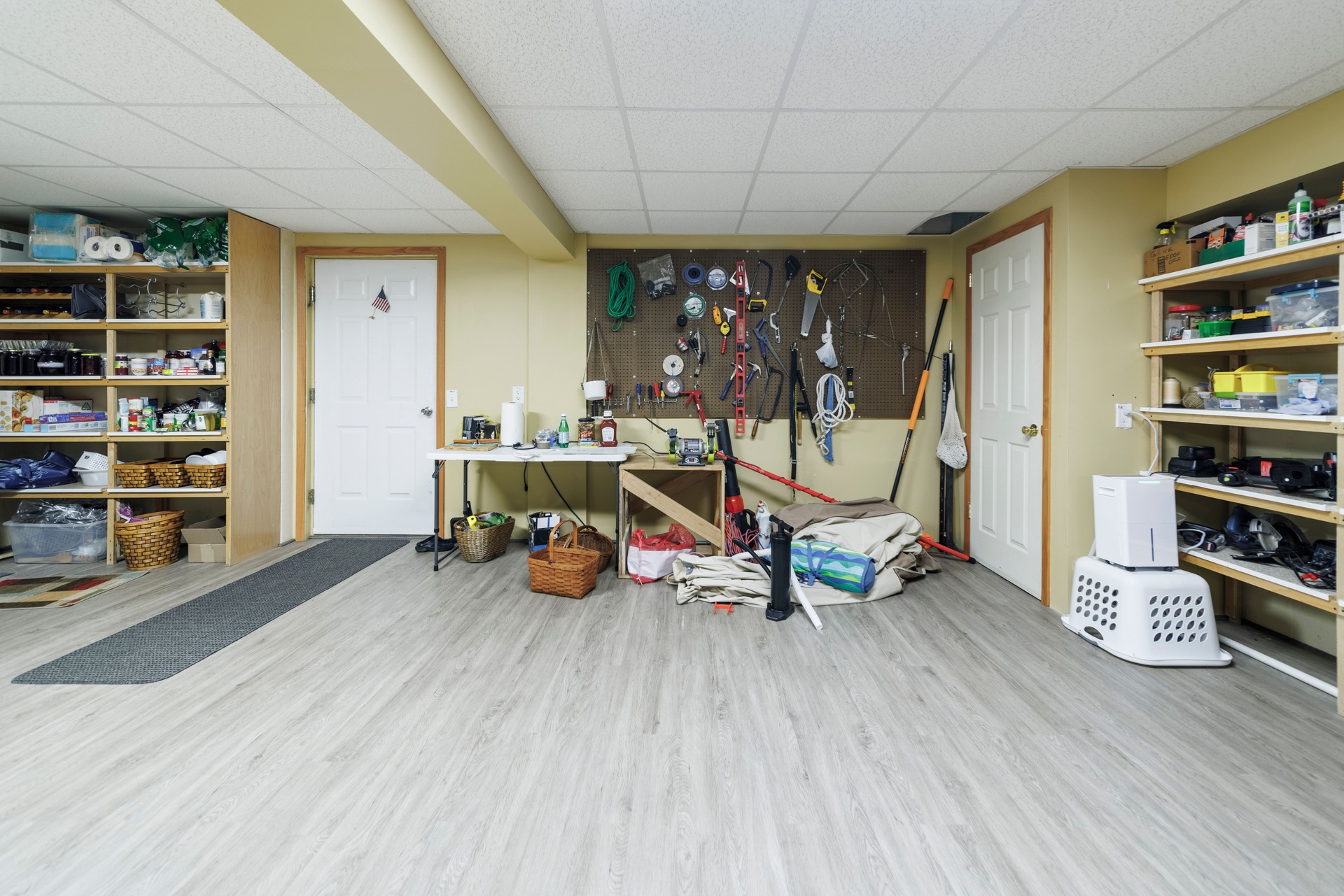 Crafting DIY haven in basement. Organized storage area with shelving and pegboard for home projects.